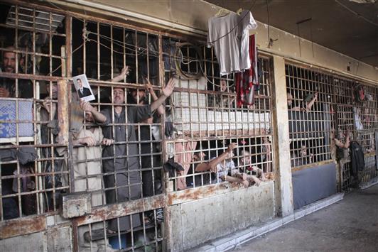 مساجين في سجن حلب المركزي يحتفلون امس بدخول الجيش السوري اليه (رويترز)