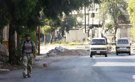 مسلح يسير في احد شوارع حلب امس (رويترز)