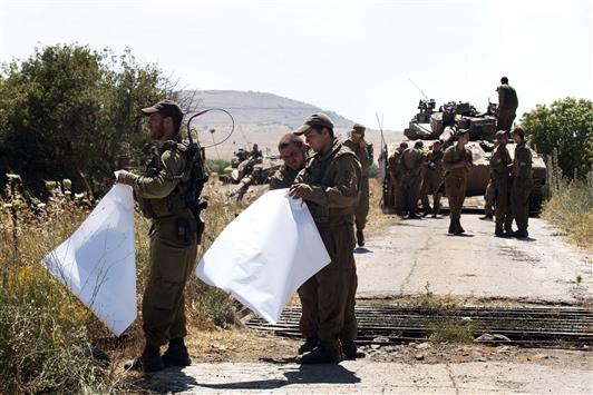 جنود اسرائيليون يحملون خرائط في الجولان السوري المحتل امس (ا ف ب)