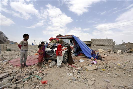 اطفال فروا مع عائلتهم من عمران قرب آلية حولت الى "منزل" في صنعاء امس (ا ب ا)