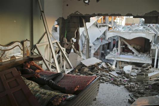 شاب ينام داخل غرفته المدمّرة في بيت حانون في غزة أمس (رويترز)