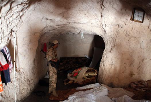 جندي سوري داخل مغارة امس استخدمها المسلحون كمقر لهم في ريف حماه (ا ف ب)