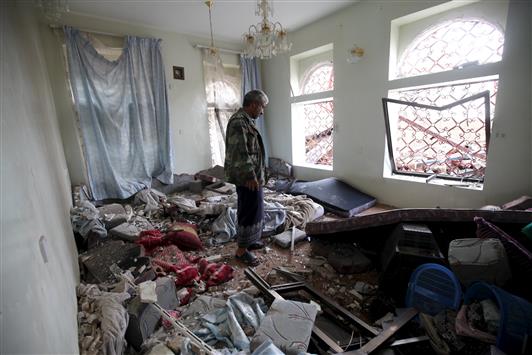 رجل يتفقد منزله الذي تضرَّر جراء القصف على صنعاء. (رويترز)