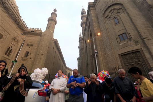 مصلون يؤدون صلاة عيد الفطر أمام أحد الجوامع في القاهرة القديمة اليوم (رويترز)