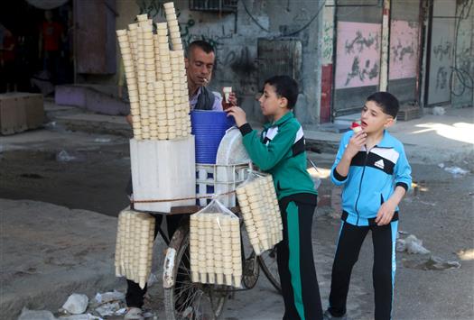 أطفال يشترون المثلجات في يوم عيد المفطر في حلب (رويترز)