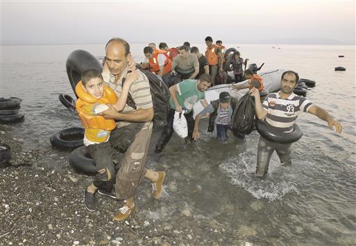 سوريون لدى وصولهم الى جزيرة كوس اليونانية امس (رويترز)