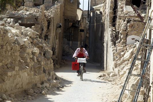 شاب على دراجة هوائية في أحد شوارع حلب القديمة أمس الأول (رويترز)