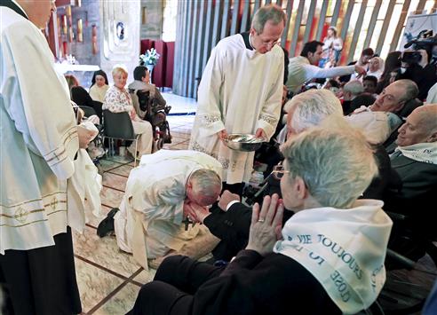 البابا فرنسيس يقبل قدمي أحد المؤمنين في روما ربيع العام 2014 (رويترز)