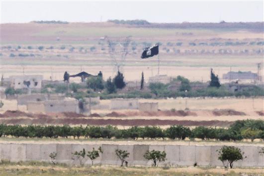 علم «داعش» يرفرف في منطقة سورية على الحدود التركية امس الاول (ا ف ب)