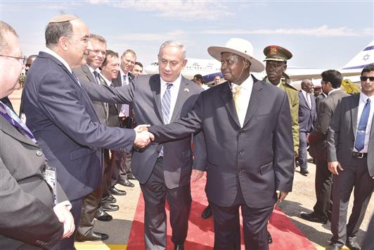 نتنياهو يقدم أعضاء وفده للرئيس الأوغندي في مطار عينتيبي أمس (رويترز)