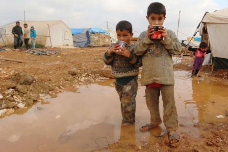 طفلان سوريان نازحان في مخيم باب السلامة عند الحدود السورية التركية أمس (أ ف ب)