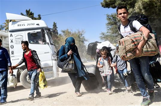 لاجئون سوريون يعودون من تركيا إلى جرابلس السورية عبر معبر قرقميش يوم الأربعاء الماضي (أ ف ب)