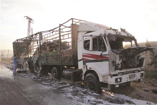 شاحنة محترقة من قافلة المساعدات الإنسانية بعد تعرضها لهجوم أثناء توجهها إلى بلدة أورم الكبرى غرب حلب أمس (أ ف ب)