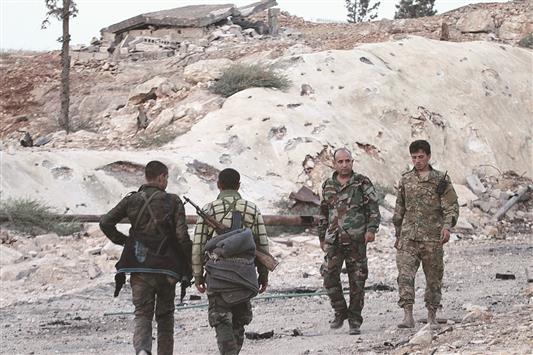 عناصر من الجيش السوري داخل مزارع جنوب غرب مخيم حندرات في حلب أمس الأول (أ ب أ)