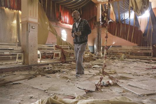 رجل يتفقد الدمار داخل صالة زفاف في بلدة تل طويل في الحسكة استهدفها هجوم انتحاري أمس الأول (أ ف ب)
