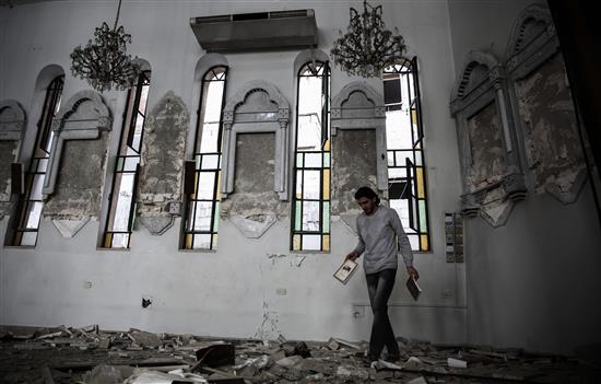 سوري يتفقّد الدمار الذي لحق بكنيسة القديس الياس الغيور في حرستا أمس الاول (ا ف ب)