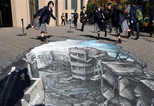 طلاب يستعدون لاتخاذ صورة قرب رسم بالابعاد الثلاثية تمثل مجينة حلب المدمرة داخل حرم جامعة ميجي في طوكيو أمس (أ ف ب)