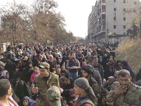 سوريون يتحضرون لمغادرة حي الصالحين المحرر شرق حلب أمس (أ ب أ)