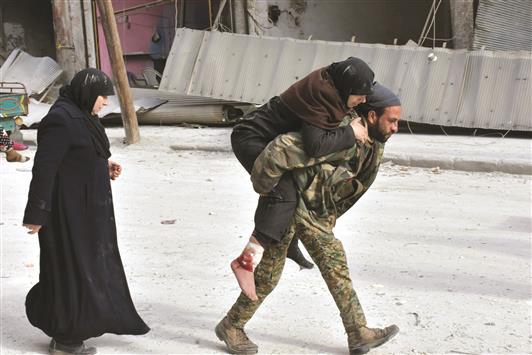 جندي سوري يساعد امرأة مسنّة مصابة في الاحياء الشرقية لحلب أمس (أ ب أ)