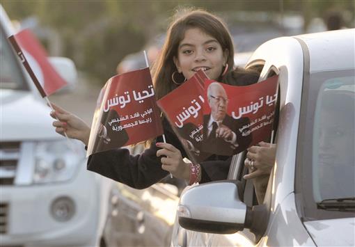 طفلة تونسية ترفع صورة السبسي خلال احتفالات بفوزه بالرئاسة في تونس أمس (أ ف ب)