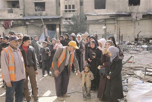 فلسطينيون ينتظرون في مخيم اليرموك قرب دمشق امس الاول للحصول على مساعدات من «الاونروا» (ا ف ب)