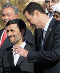 الأسد ونجاد يتحادثان خلال التقاط الصورة الرسمية للوفود المشاركة في القمة الإسلامية في اسطنبول أمس.