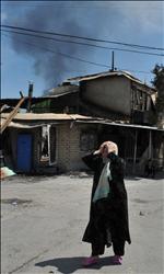 امرأة من الاثنية الأوزبكية تبكي أمام بيتها المحترق في أوش أمس