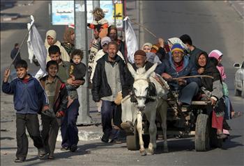 صورة من الأرشيف لفلسطينيين يحملون رايات بيضاء في مخيم جباليا خلال الحرب الإسرائيلية على غزة العام الماضي