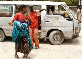 صومالي يحمل طفله الجريح إلى مستشفى في مقديشو