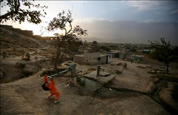 طفلة تستعين بكل قوتها لاستخراج المياه من أنبوب في كابول أمس