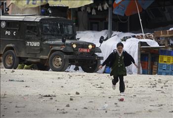 طفلة فلسطينية تبحث عن مكان تحتمي فيه خلال المواجهات في مخيم شعفاط أمس