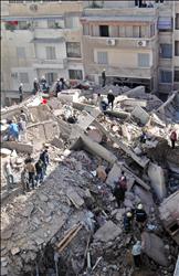 عمال إنقاذ في موقع المبنى المنهار في الإسكندرية أمس
