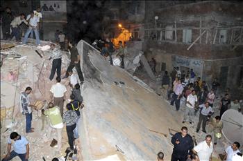 عمال إنقاذ يفتشون عن ناجين، أو جثث، بين أنقاض المبنى المتهدم وسط الإسكندرية أمس