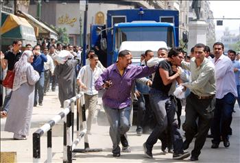 عناصر أمن مصريون بلباس مدني يعتقلون متظاهراً في القاهرة أمس.