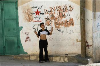 فتى فلسطيني يقف مذعوراً خلال تقدم جنود الاحتلال في مخيم الفارعة في الضفة الغربية أمس.