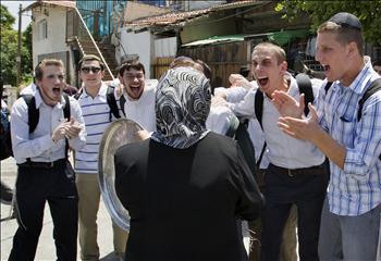 فلسطينية احتل المستوطنون منزلها تواجه إسرائيليين يشاركون في احتفالات أمام منزلها في حي الشيخ جراح في القدس أمس.