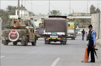 قوات عراقية ترافق شاحنات تنقل صناديق اقتراع بعد إنتهاء العد في بغداد أمس