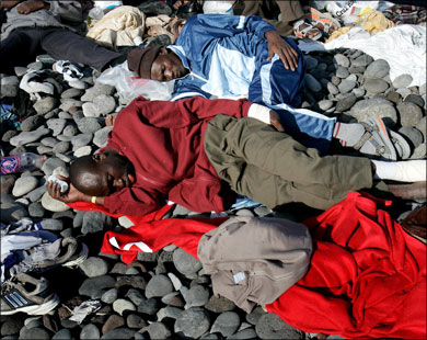 مهاجرون ينامون وقد هدهم التعب بعد رسو قاربهم على شاطئ بجزر الكناري.