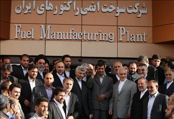 نجاد يتوسط المسؤولين والتقنيين الإيرانيين أمام المصنع في أصفهان أمس.