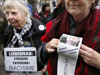 هولندية تحمل لفافة ورق مراحيض عليها صور لليبرمان، خلال تظاهرة مناهضة لزيارته للاهاي، أمس.